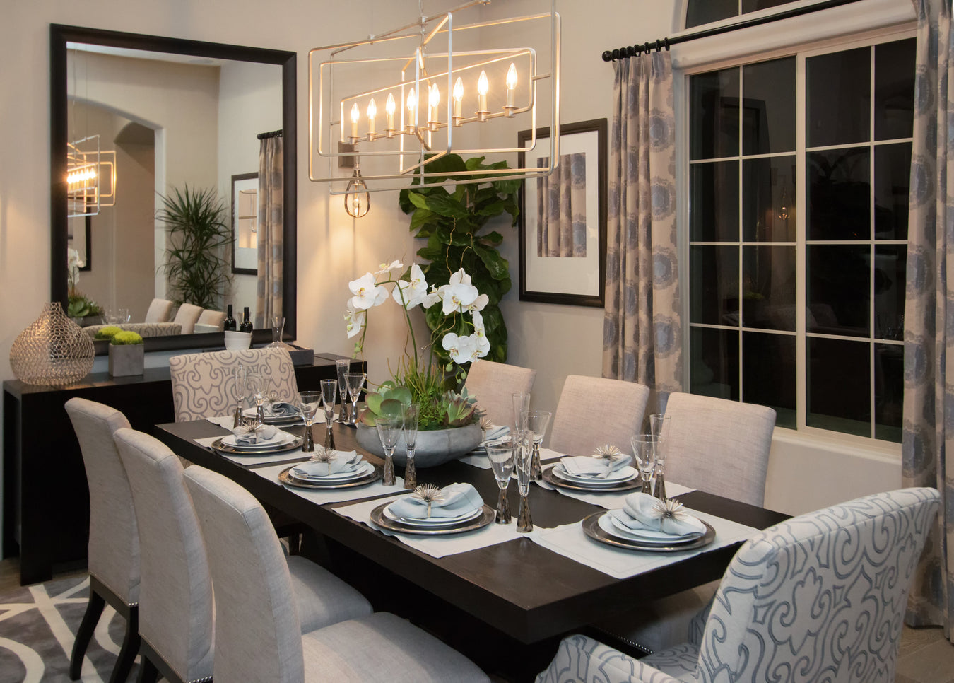 Formal dining room showing dining table, dining chairs, mirror and chandelier, home decor