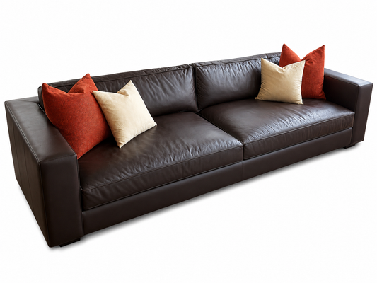 A dark brown leather five-seater sofa with four decorative throw pillows.