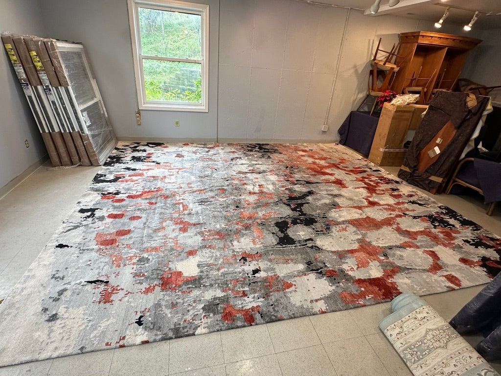 Grand Expressions Gallery and Home Store large 13x15 wool rug with abstract rusty-red, grey, cream, and black pattern.