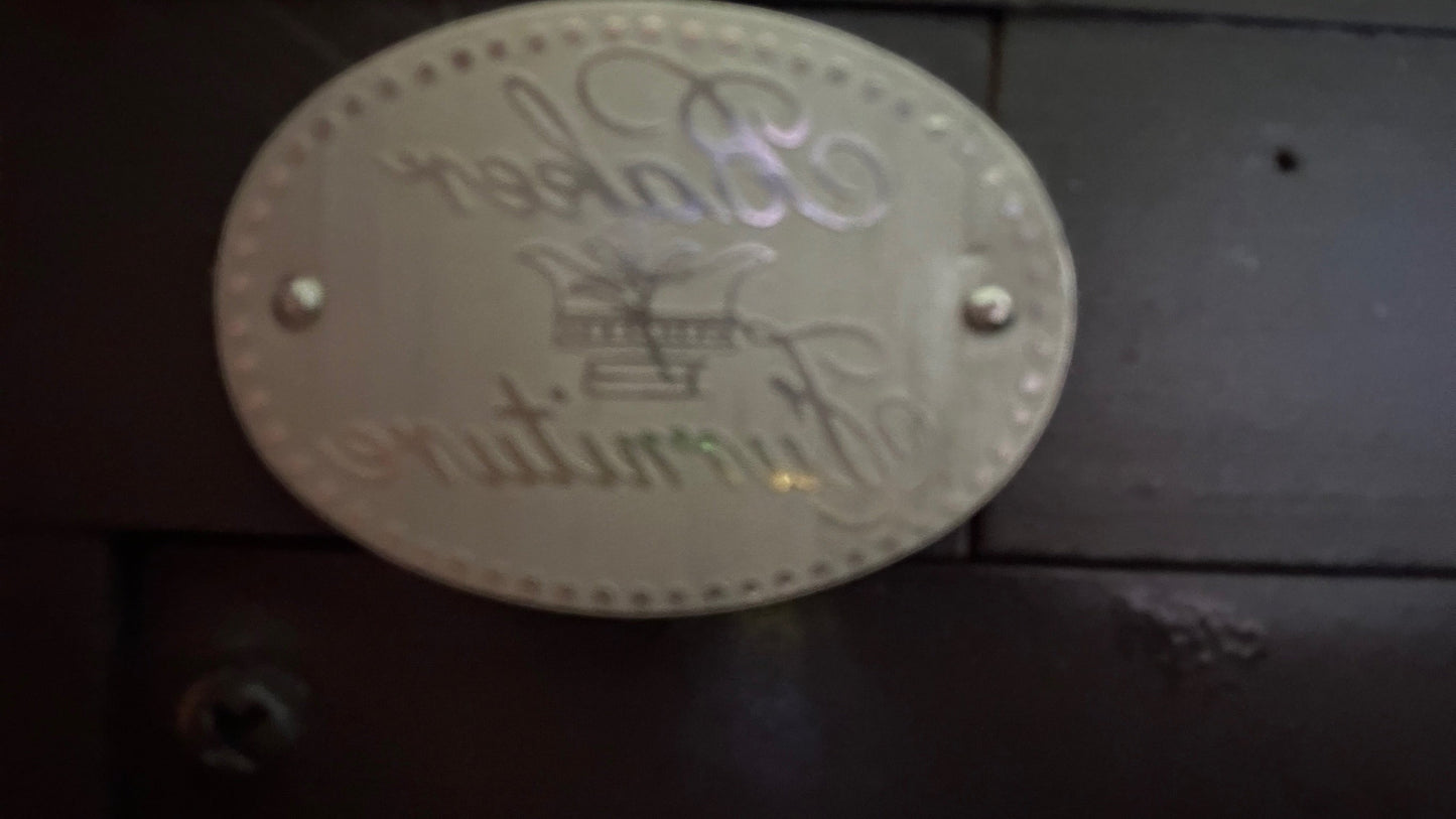 Baker Furniture metal brand plaque on a dark wood credenza from Grand Expressions Gallery and Home Store