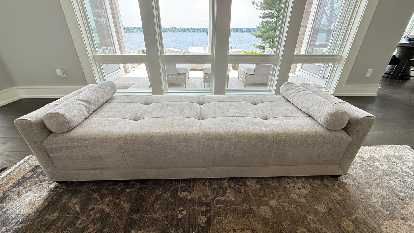 Grand Expressions Gallery and Home Store beige Baker Paris chaise lounge with tufted seat and two bolster pillows.