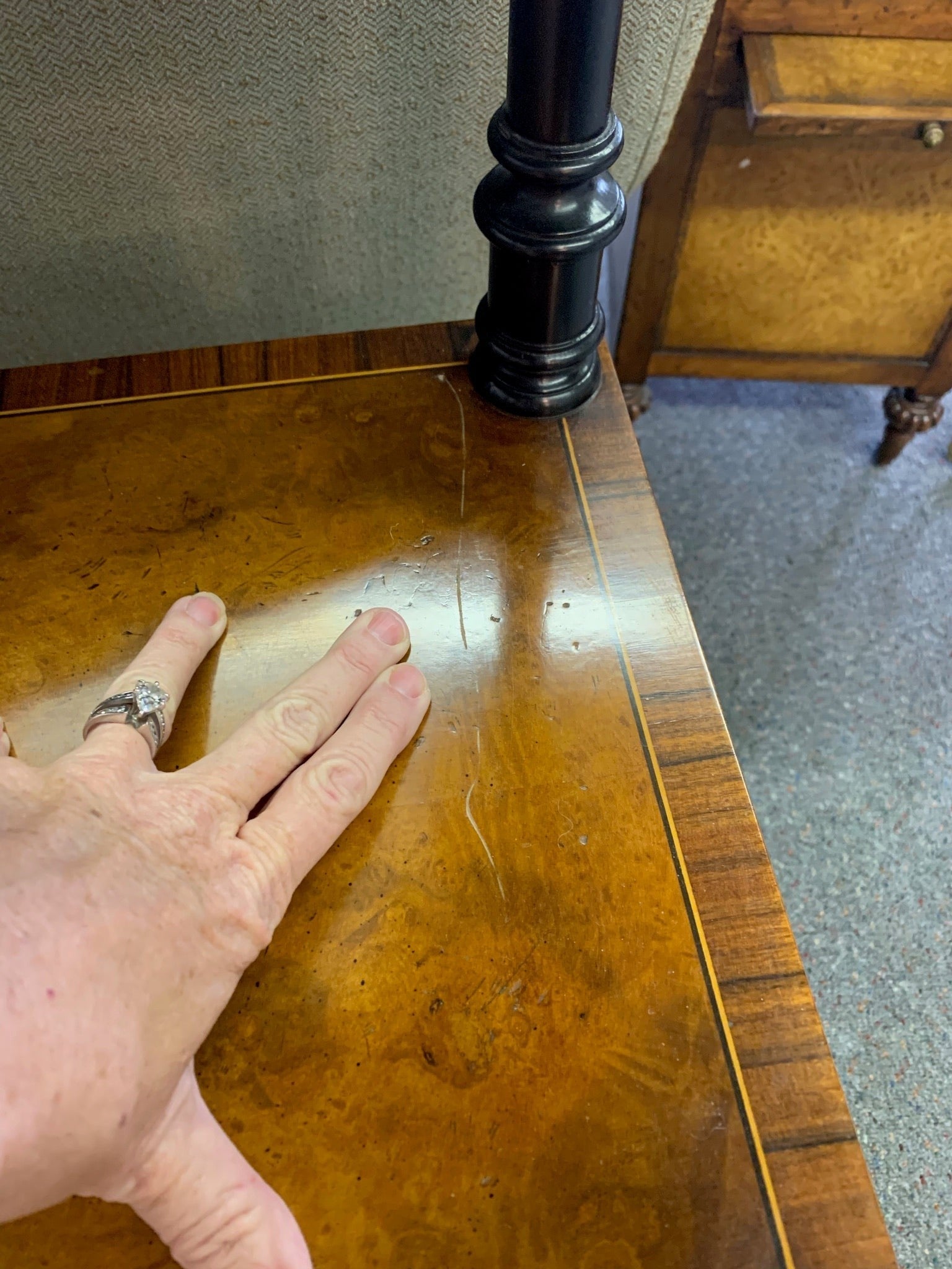 Grand Expressions Gallery and Home Store Italian burled wood shelf surface with black trim and visible surface scratch.