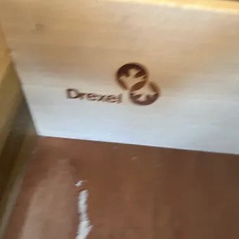 Drexel brand logo stamped on the interior wood drawer of a Grand Expressions Gallery and Home Store furniture piece.