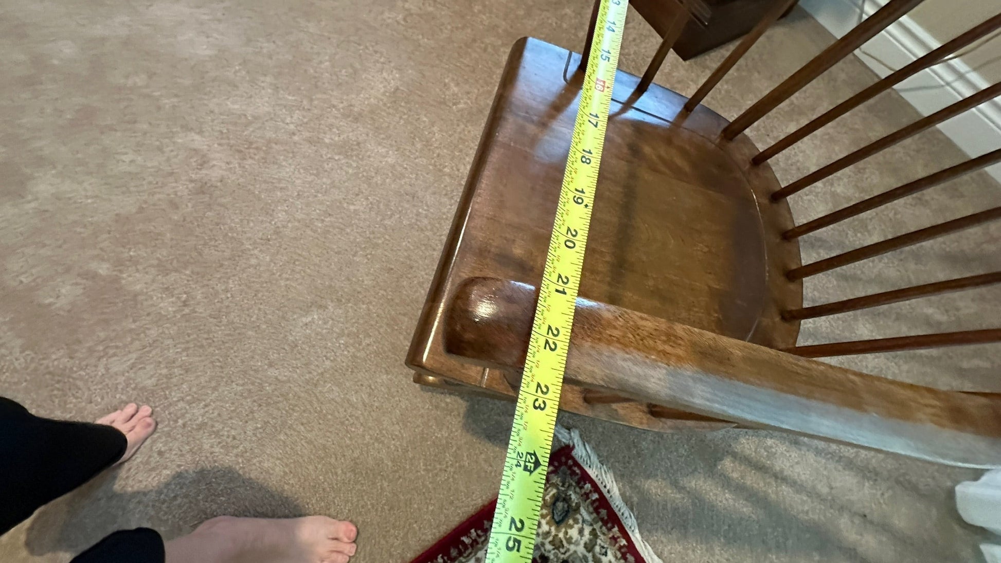 Vintage Ethan Allen wood rocking chair in brown finish, shown with a measuring tape for scale at Grand Expressions Gallery and Home Store.