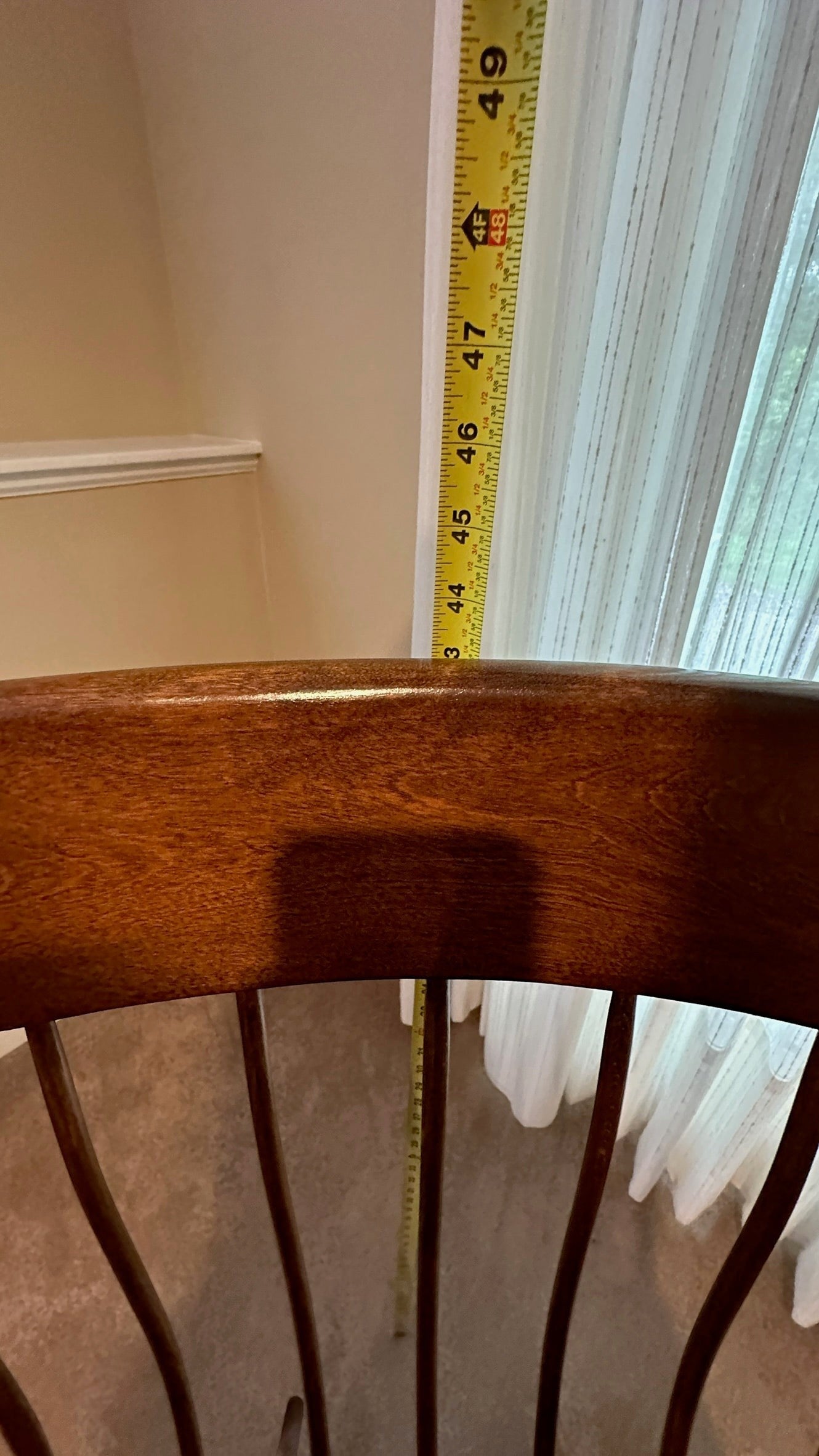 Vintage Ethan Allen wood rocking chair from Grand Expressions Gallery and Home Store with measuring tape for height.