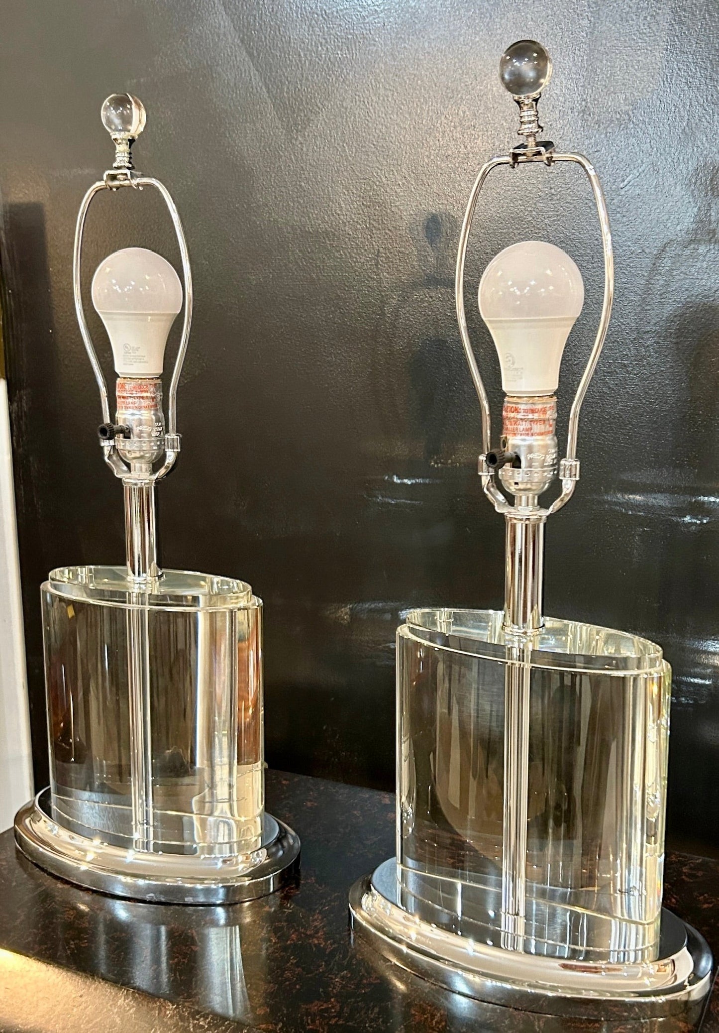Grand Expressions Gallery and Home Store set of two oval crystal table lamps with polished chrome bases.