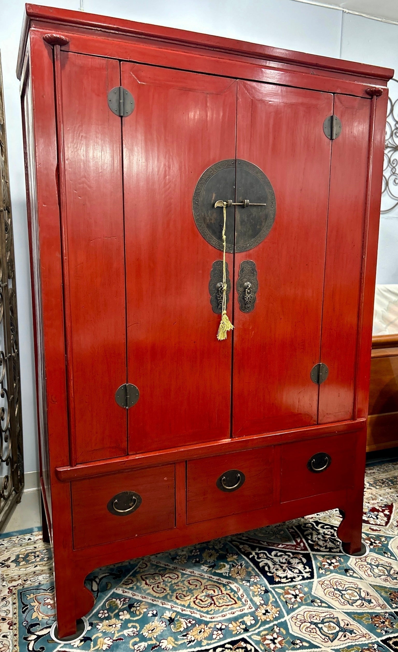 Grand Expressions Gallery and Home Store red elm wood media cabinet armoire with brass hardware and three base drawers.