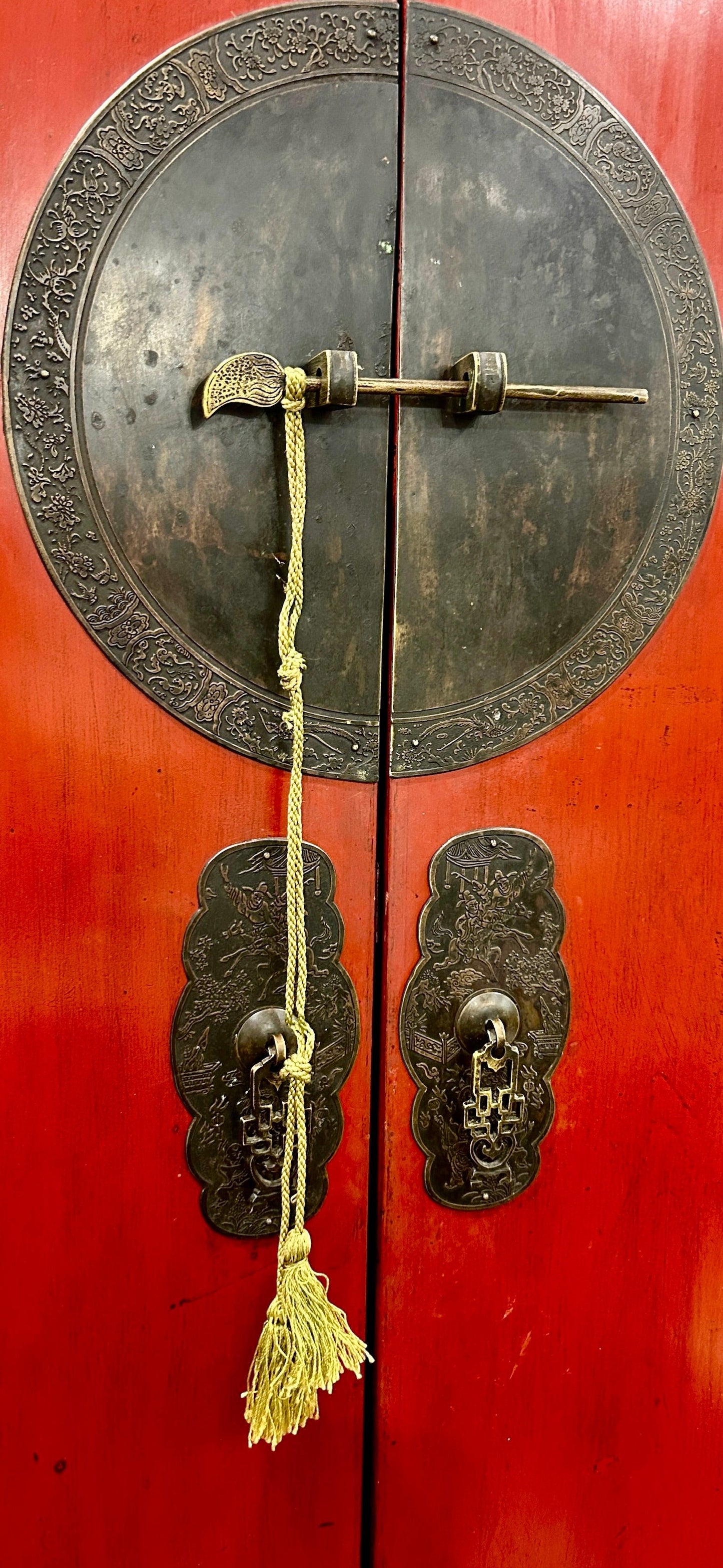 Grand Expressions Gallery and Home Store red lacquer media cabinet with ornate oiled brass hardware and tassel detail.
