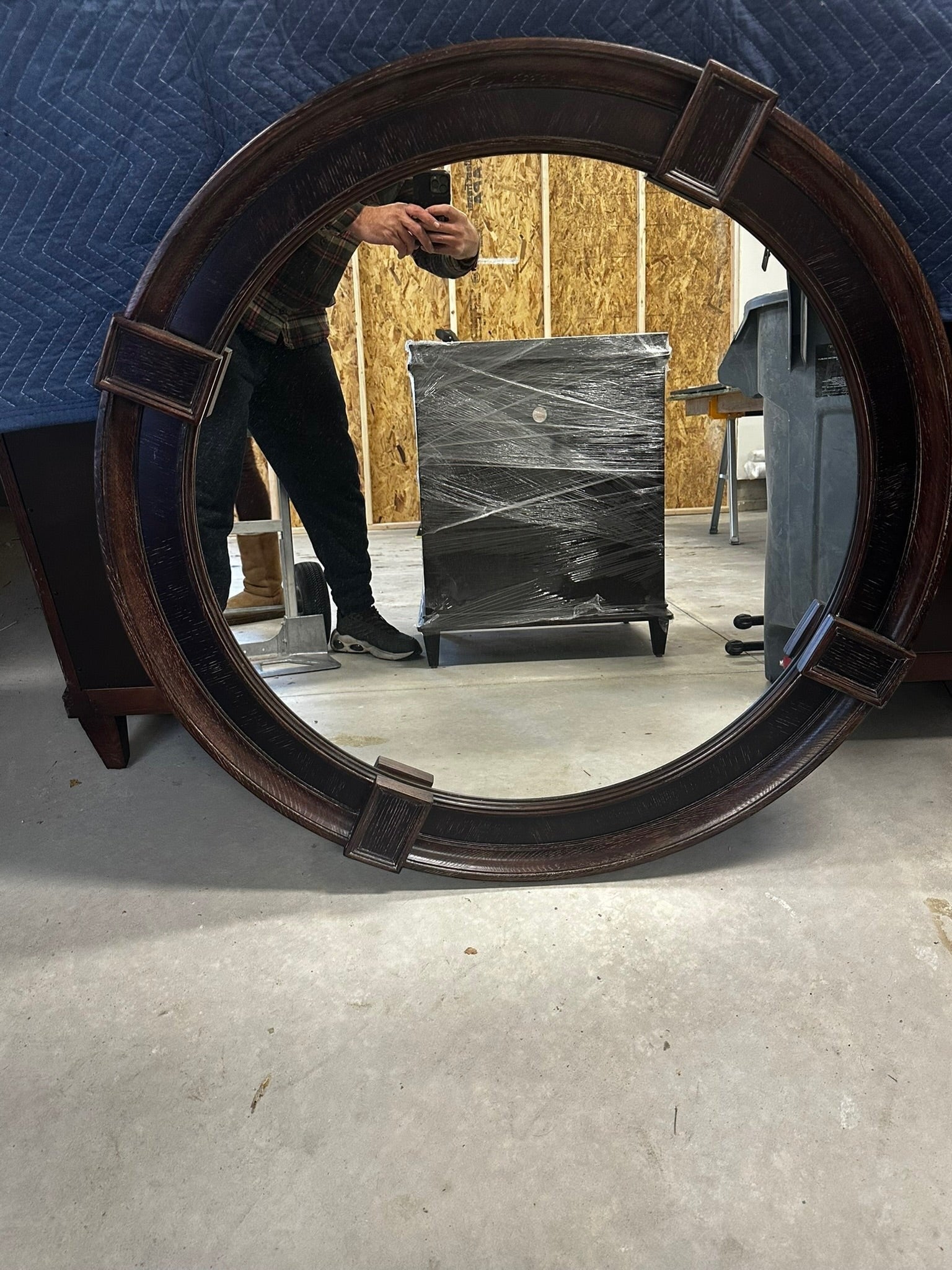 Grand Expressions Gallery and Home Store oversized round mirror with a rustic dark brown distressed wood frame.