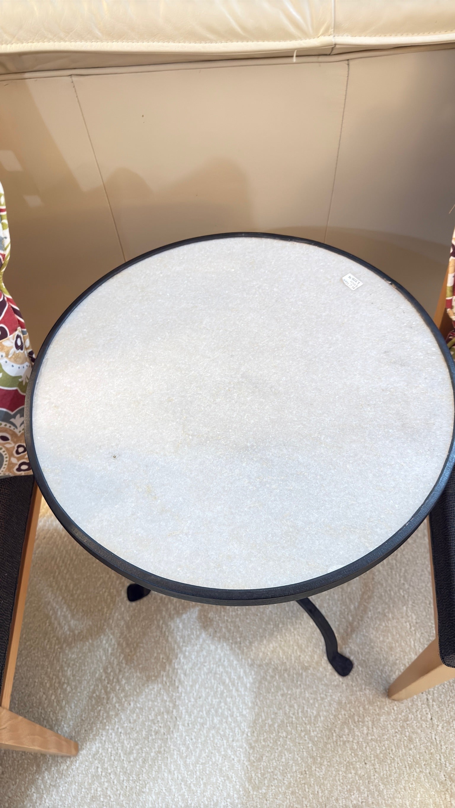 Grand Expressions Gallery and Home Store small round side table with white stone top and black twisted metal base.
