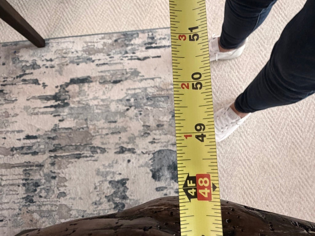 Grand Expressions Gallery and Home Store natural slab wood dining table showing width measurement with tape measure