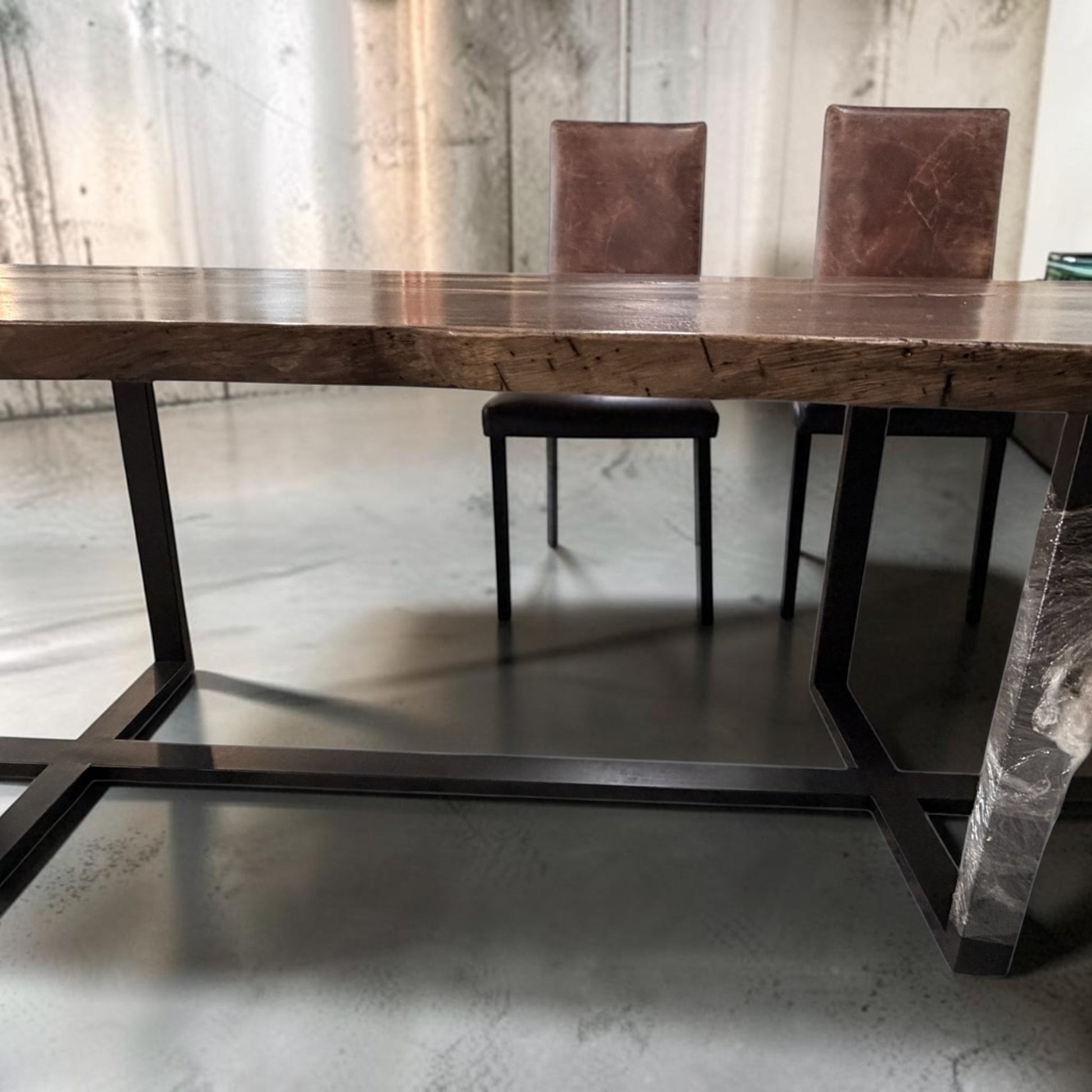 Grand Expressions Gallery and Home Store extra long natural slab wood dining table with a black metal base.