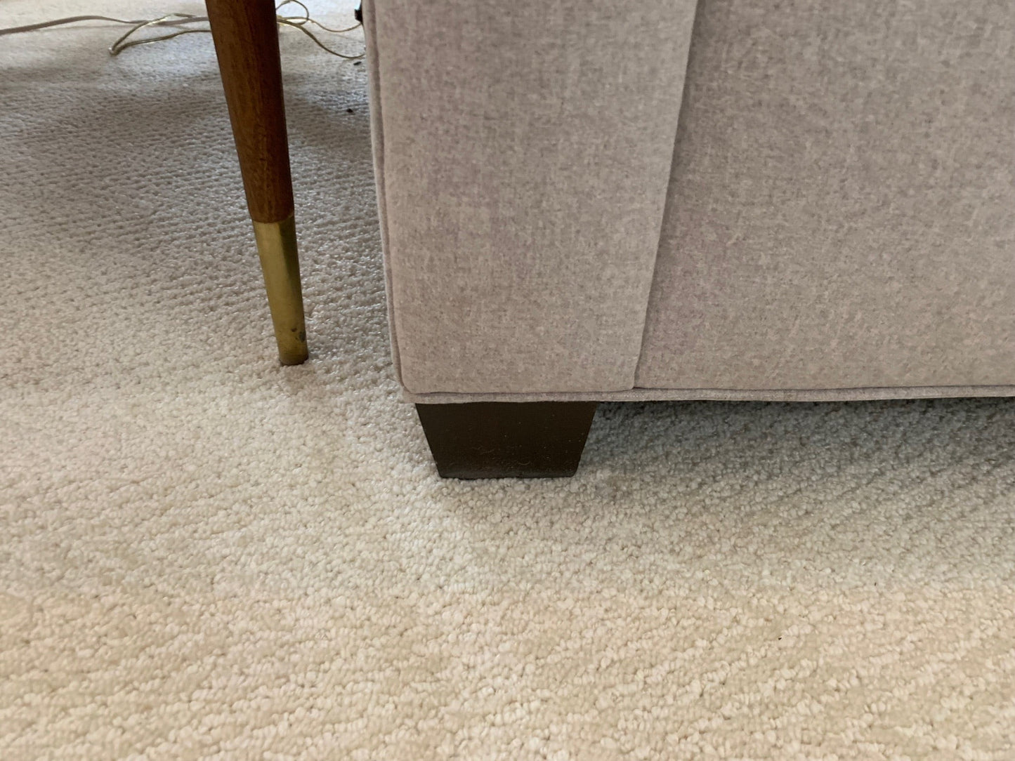 Beige fabric sofa base and wooden leg from Grand Expressions Gallery and Home Store, featuring a tailored design.