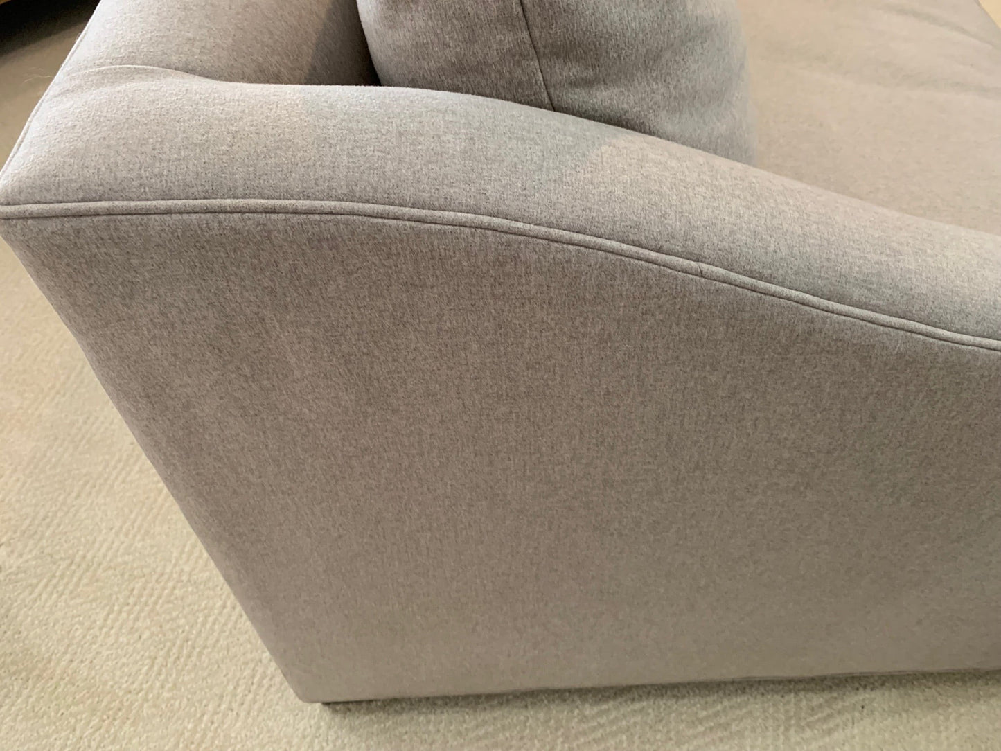 Grand Expressions Gallery and Home Store Sullivan sofa featuring light gray fabric, shelter arms, and loose cushions.