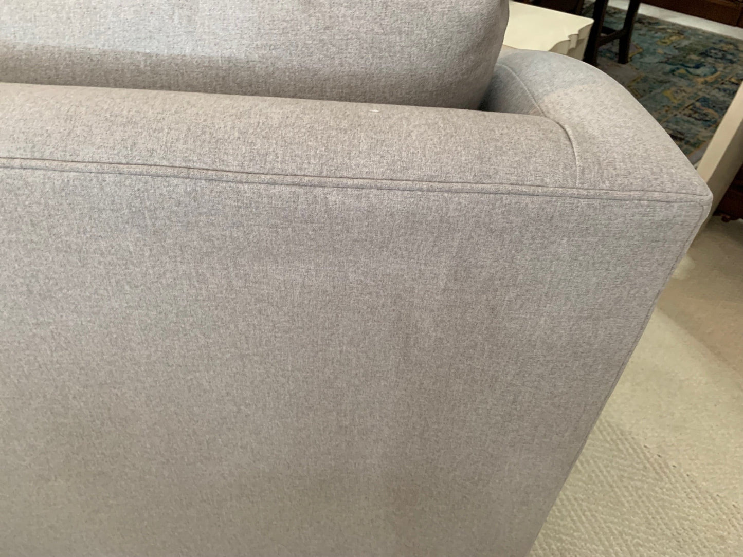 Close-up of the light grey fabric and shelter arm detail on The Sullivan Sofa by Grand Expressions Gallery and Home Store