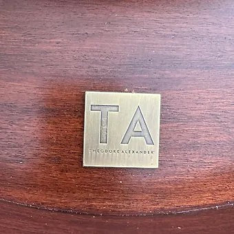 Grand Expressions Gallery and Home Store Theadore Alexander Louis XV side table brass logo plaque on wood surface